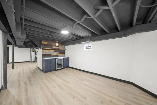 a view of an empty room with kitchen and a window