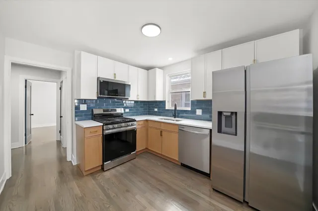 a kitchen with a refrigerator stove and wooden cabinets