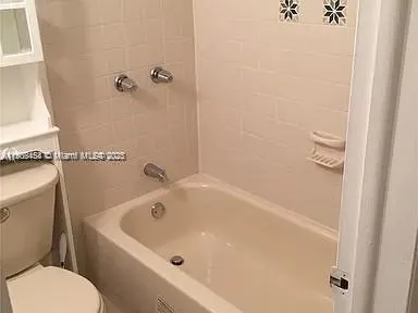 a white bath tub sitting next to a white toilet