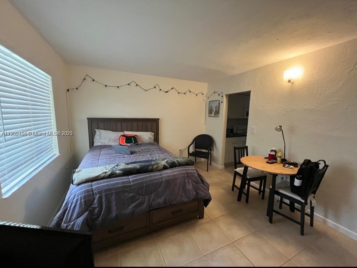 8601 Southwest 68th Court, Unit 2 Pinecrest, FL 33156 - Photo 6 of 7 a bedroom with furniture and a chair