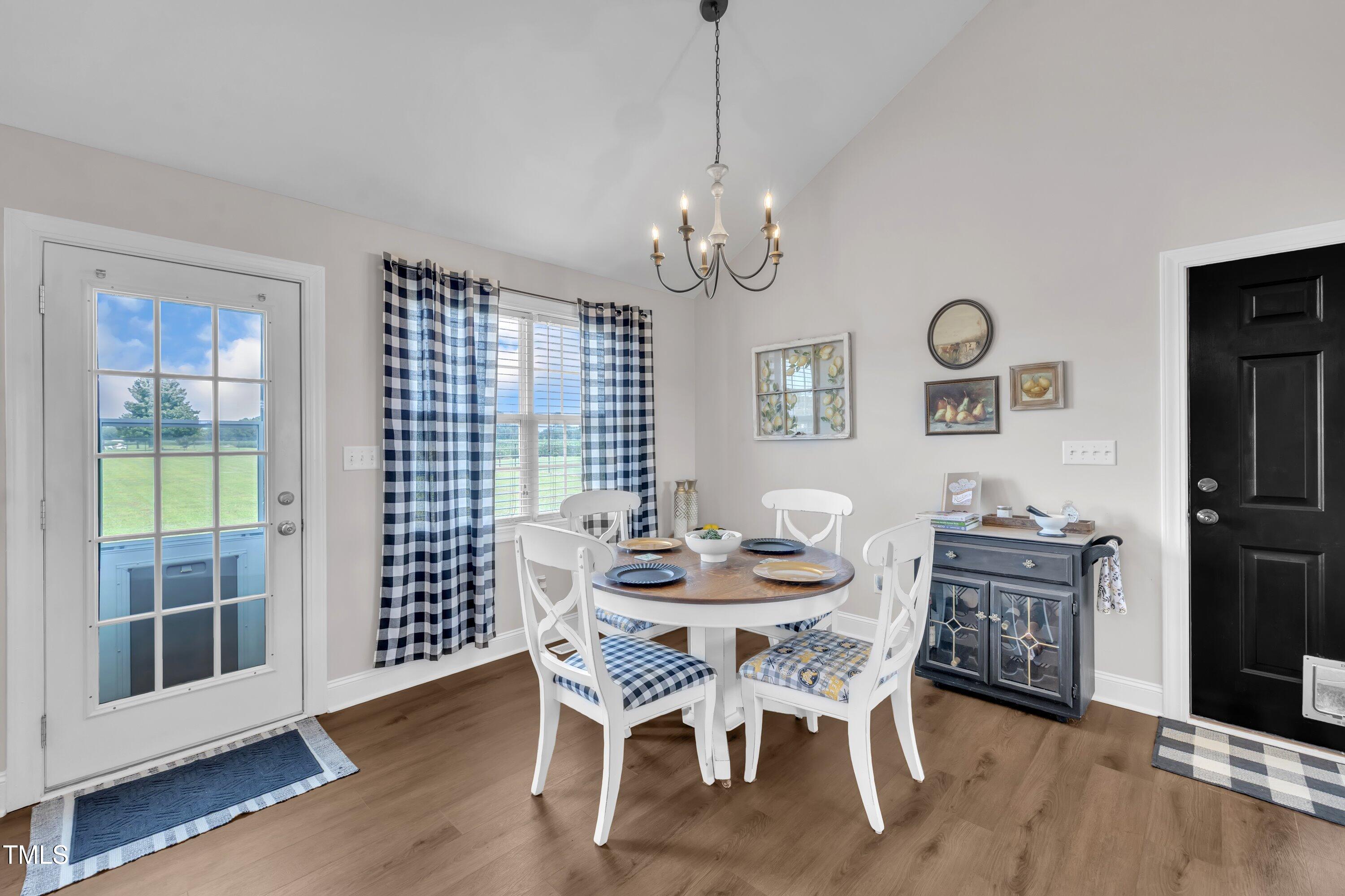 6953 Rock Ridge Sims Road Sims, NC 27880 - Photo 13 of 29 a dining room with wooden floor a chandelier a wooden table and chairs