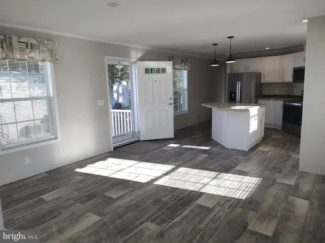 a view of kitchen and hall with wooden floor