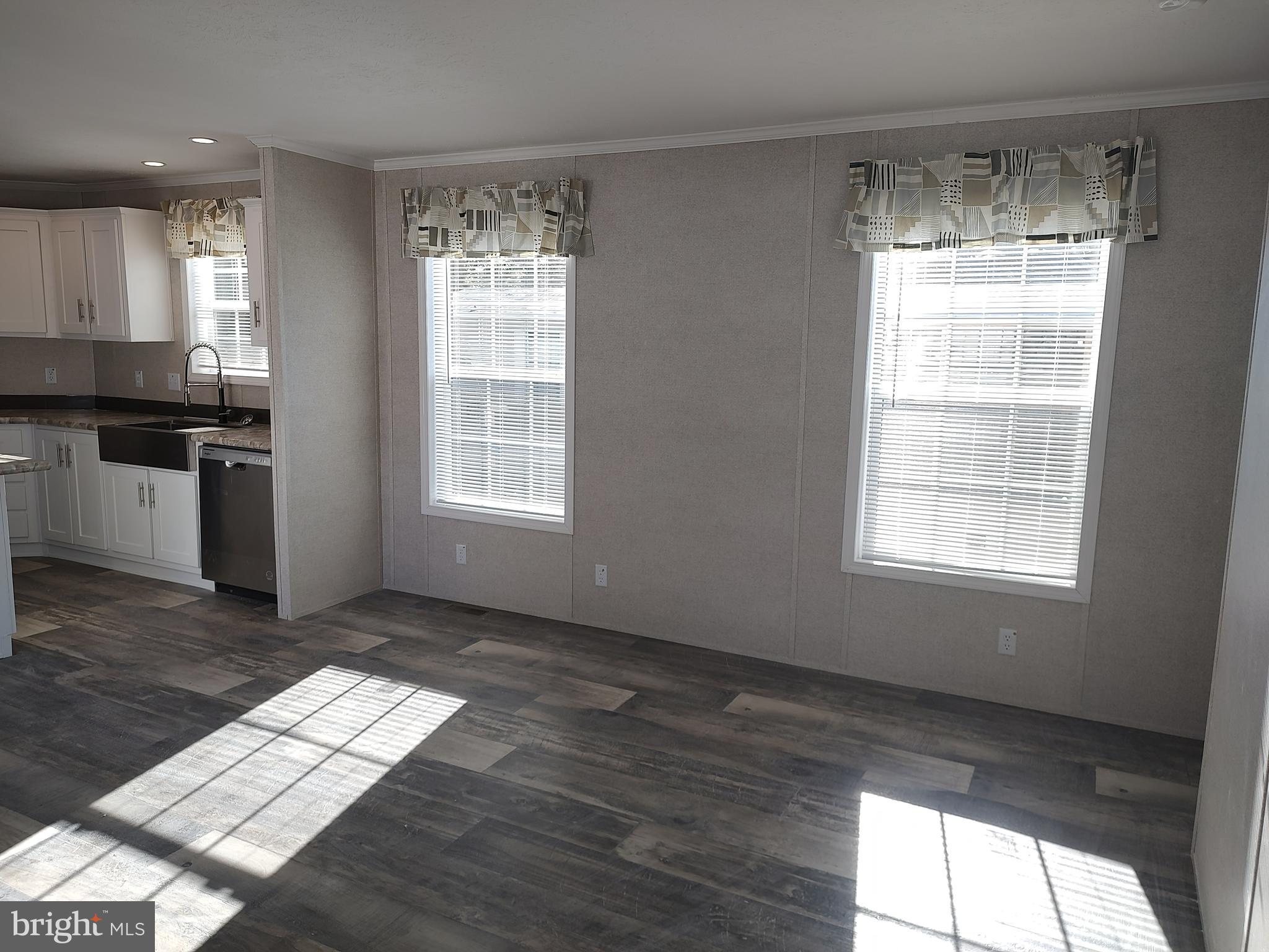 12623 Shell Mill Road, Unit 51 Bishopville, MD 21813 - Photo 15 of 41 a view of an empty room with wooden floor and a window