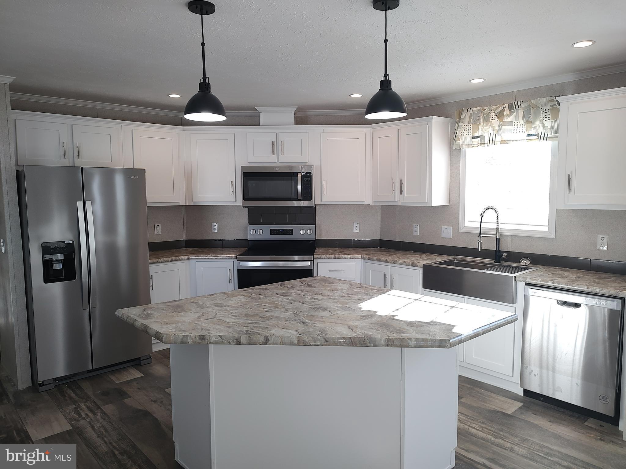 12623 Shell Mill Road, Unit 51 Bishopville, MD 21813 - Photo 17 of 41 a kitchen with stainless steel appliances granite countertop a sink a stove a refrigerator and island