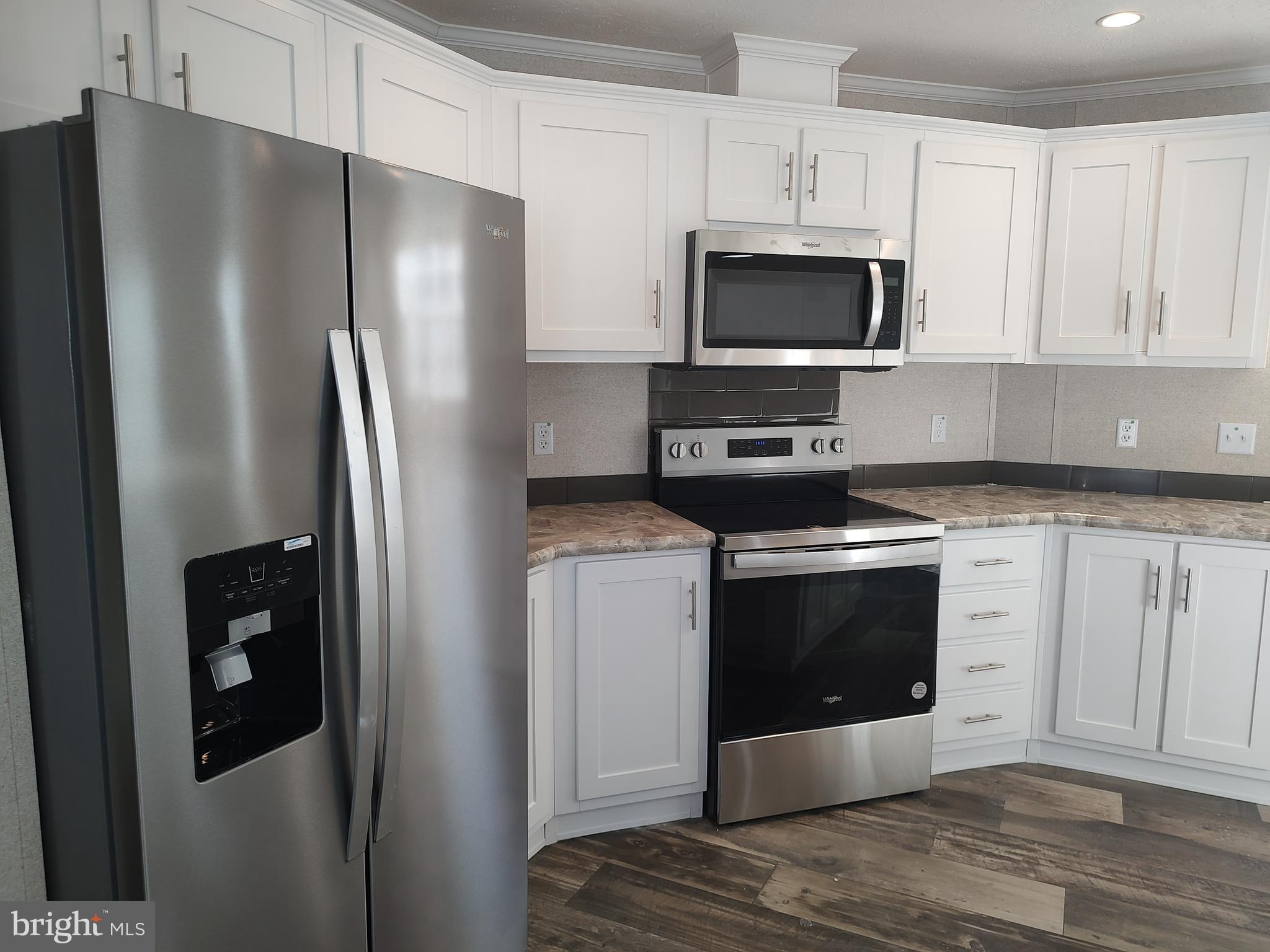 12623 Shell Mill Road, Unit 51 Bishopville, MD 21813 - Photo 19 of 41 a kitchen with stainless steel appliances a refrigerator stove and microwave