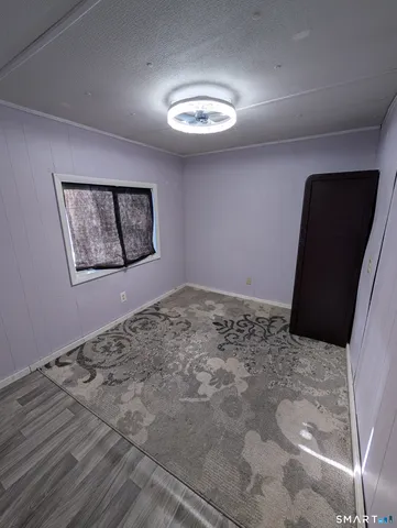 a view of a big room with wooden floor and windows