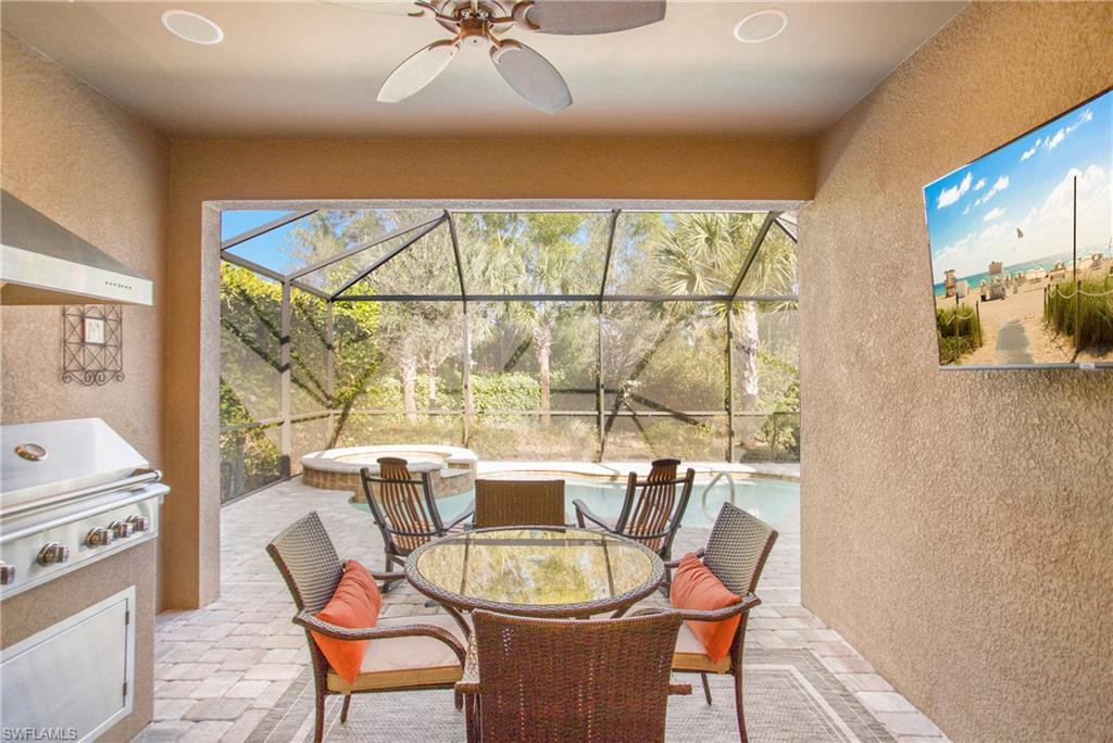 7674 Jacaranda Lane Naples, FL 34114 - Photo 18 of 45 a dining room with furniture a chandelier and wooden floor