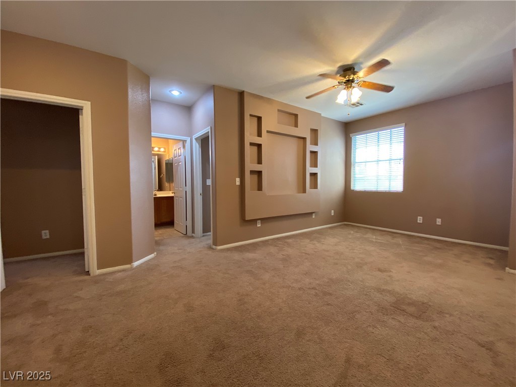 5680 Arrow Tree Street Las Vegas, NV 89130 - Photo 13 of 27 Unfurnished bedroom with light carpet, connected bathroom, and ceiling fan
