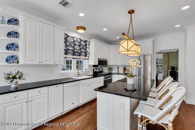 312 Essex Avenue Spring Lake, NJ 07762 - Photo 12 of 29 a kitchen with stainless steel appliances granite countertop a sink a stove and a wooden floors