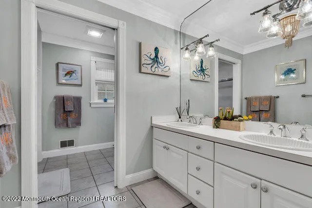 a bathroom with a double vanity sink mirror and next to a window