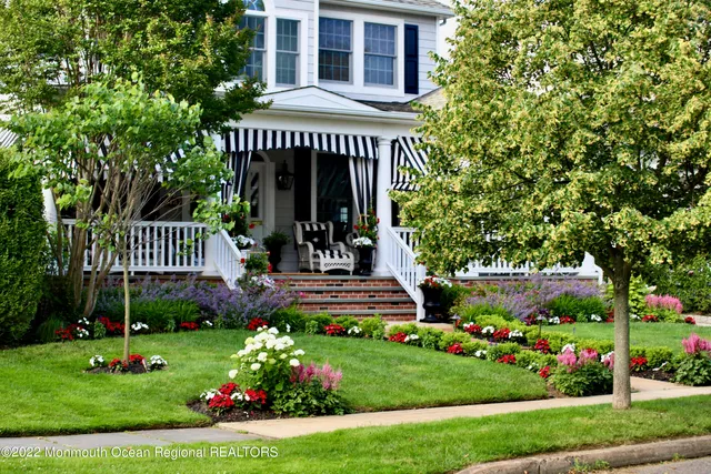 a view of a house with a yard and potted plants