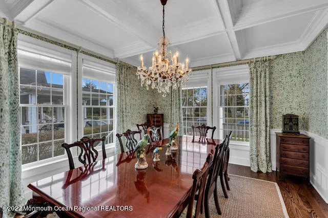 a dining room with furniture a chandelier and wooden floor
