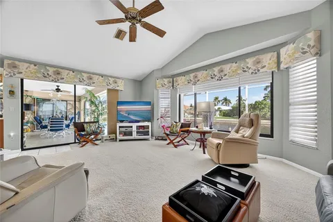 a living room with furniture a flat screen tv and a large window