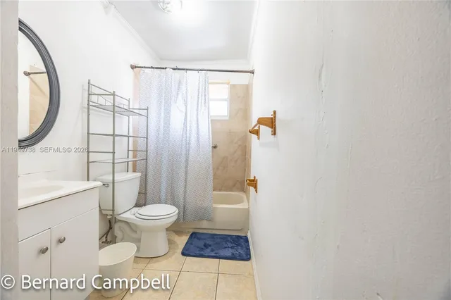 a spacious bedroom with a bed a dresser and a large mirror