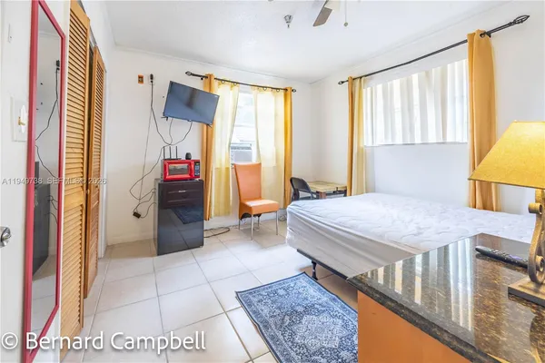 a spacious bedroom with a bed a dresser and a large mirror