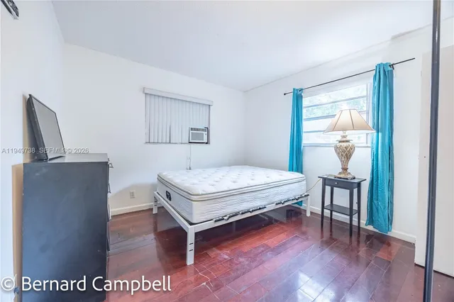 a bedroom with a bed and dresser with mirror