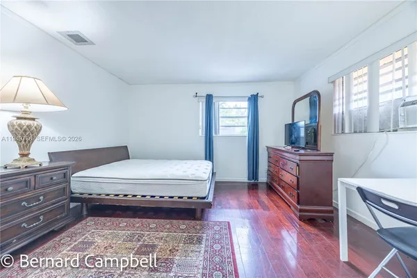 a bedroom with a bed and dresser with mirror