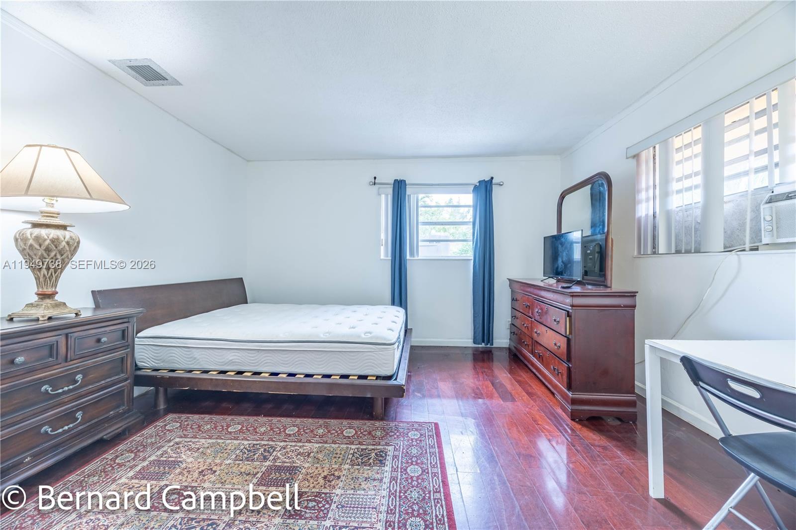 129 Southeast 5th Street, Unit 14 Hallandale Beach, FL 33009 - Photo 25 of 32 a room with a bed and a mirror on dresser