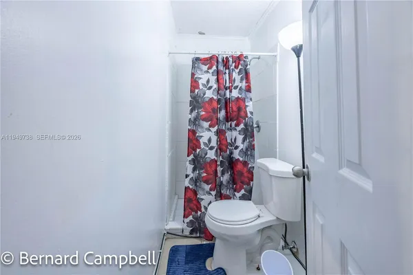 a white toilet sitting next to a shower curtain
