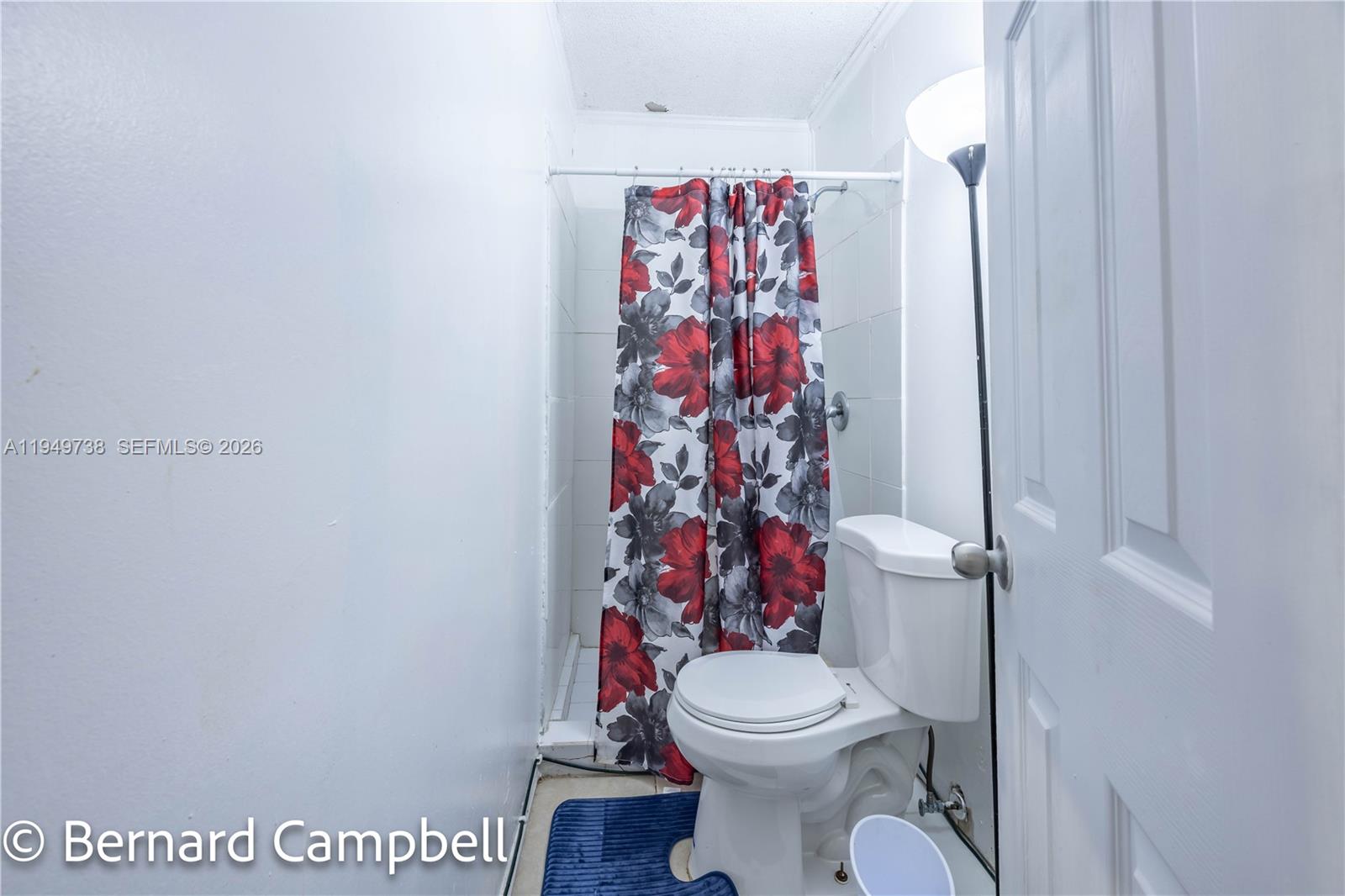 129 Southeast 5th Street, Unit 14 Hallandale Beach, FL 33009 - Photo 9 of 32 a white toilet sitting next to a shower curtain