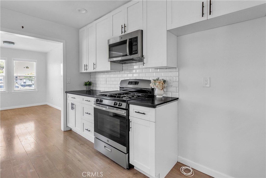 7552 11th Street Buena Park, CA 90621 - Photo 7 of 23 a kitchen with stainless steel appliances a stove a microwave and sink