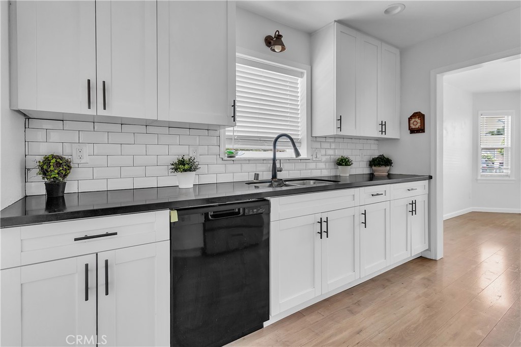 7552 11th Street Buena Park, CA 90621 - Photo 9 of 23 a kitchen with white cabinets a sink and dishwasher
