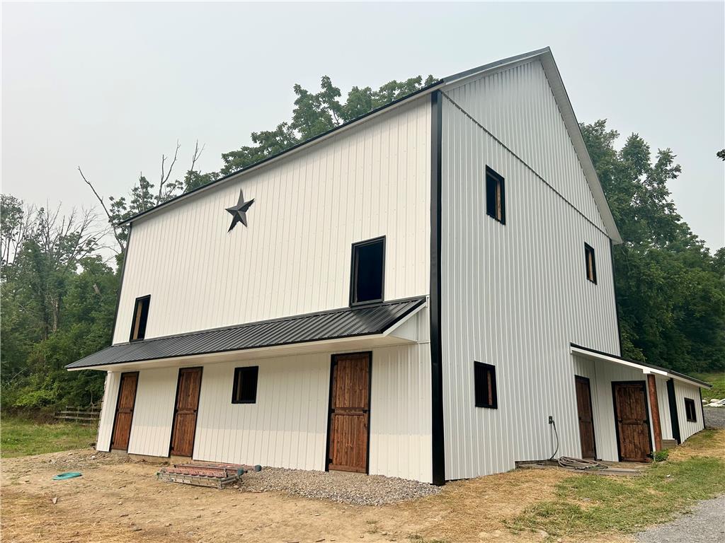 72 Allegheny Road Mount Bethel, PA 18343 - Photo 2 of 75 A newly constructed, clean-lined barn features rustic wooden doors and a classic black metal roof.