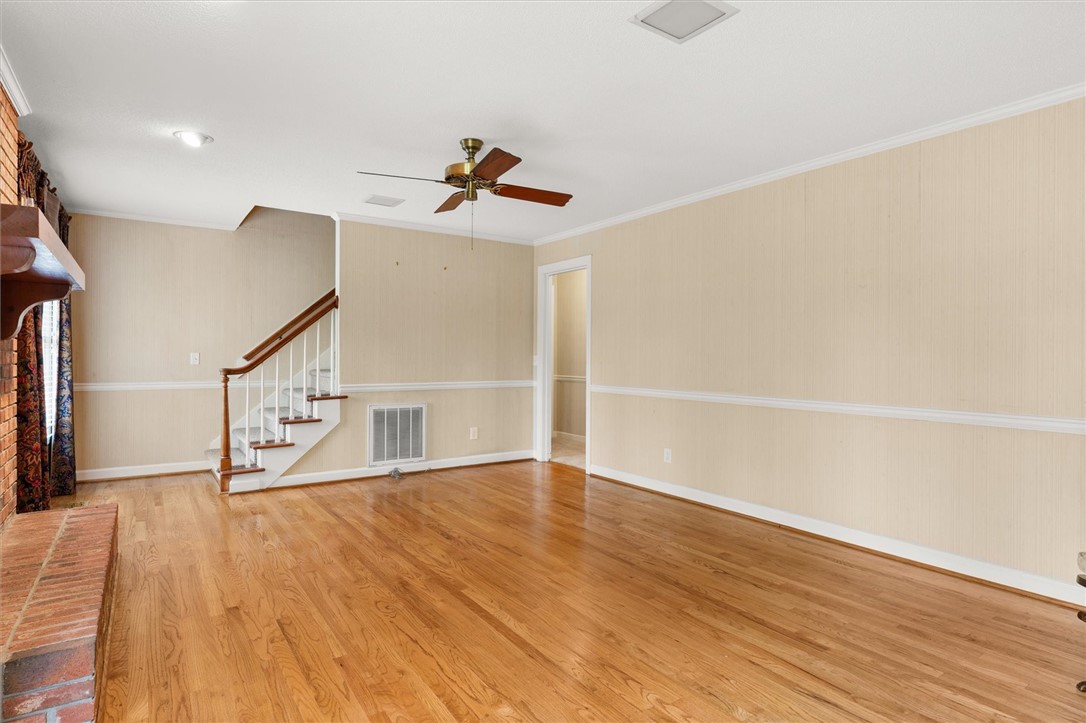 105 Hamilton Drive Anderson, SC 29621 - Photo 15 of 49 This inviting space features warm wood flooring, a charming fireplace, and convenient staircase access.