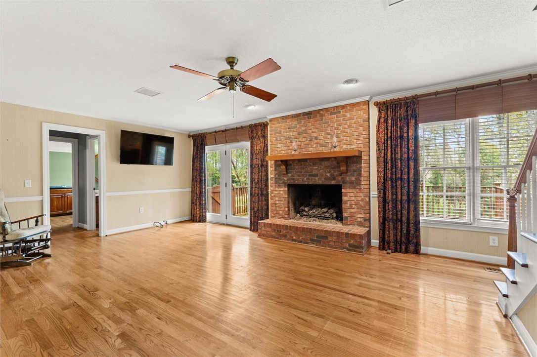 105 Hamilton Drive Anderson, SC 29621 - Photo 17 of 49 This inviting living space features warm hardwood floors and a cozy brick fireplace, perfect for gatherings.