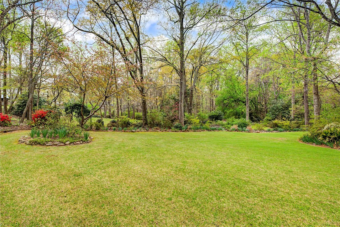 105 Hamilton Drive Anderson, SC 29621 - Photo 7 of 49 Expansive green lawn surrounded by mature trees and lush landscaping.