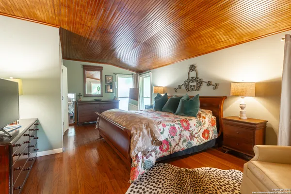 a bedroom with a bed and wooden floor