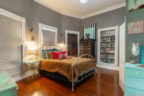 a bedroom with a bed and a bookshelf with wooden floor