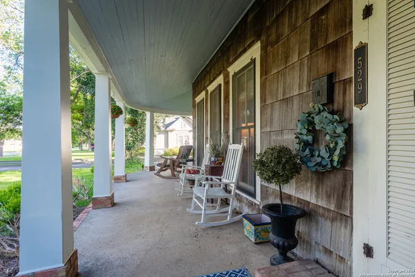 a view of a patio with plants and chairs