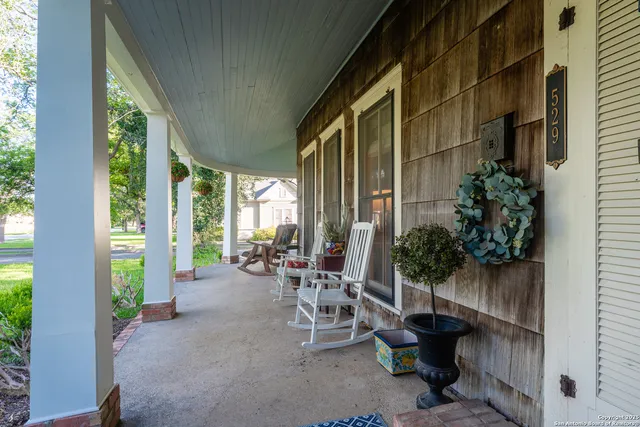a view of a patio with plants and chairs