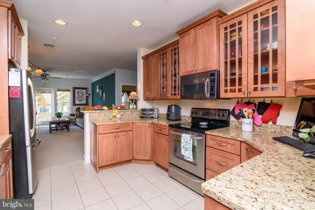a kitchen with stainless steel appliances granite countertop a stove top oven a sink dishwasher and cabinets with wooden floor