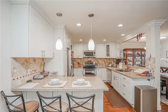 a kitchen with stainless steel appliances kitchen island granite countertop a sink and cabinets