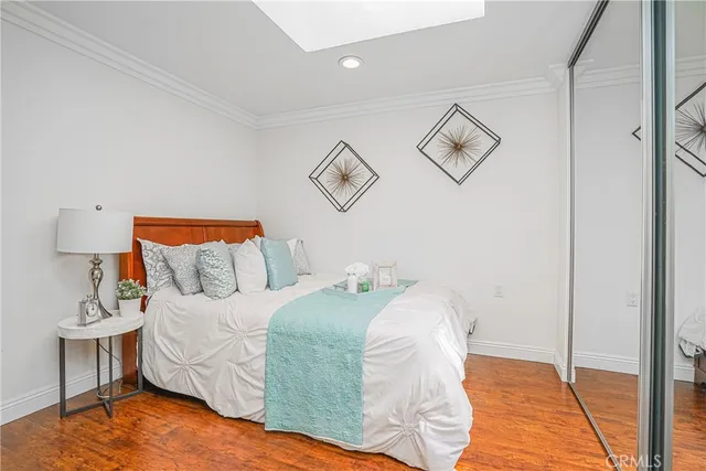 a bedroom with a bed and painting on the wall