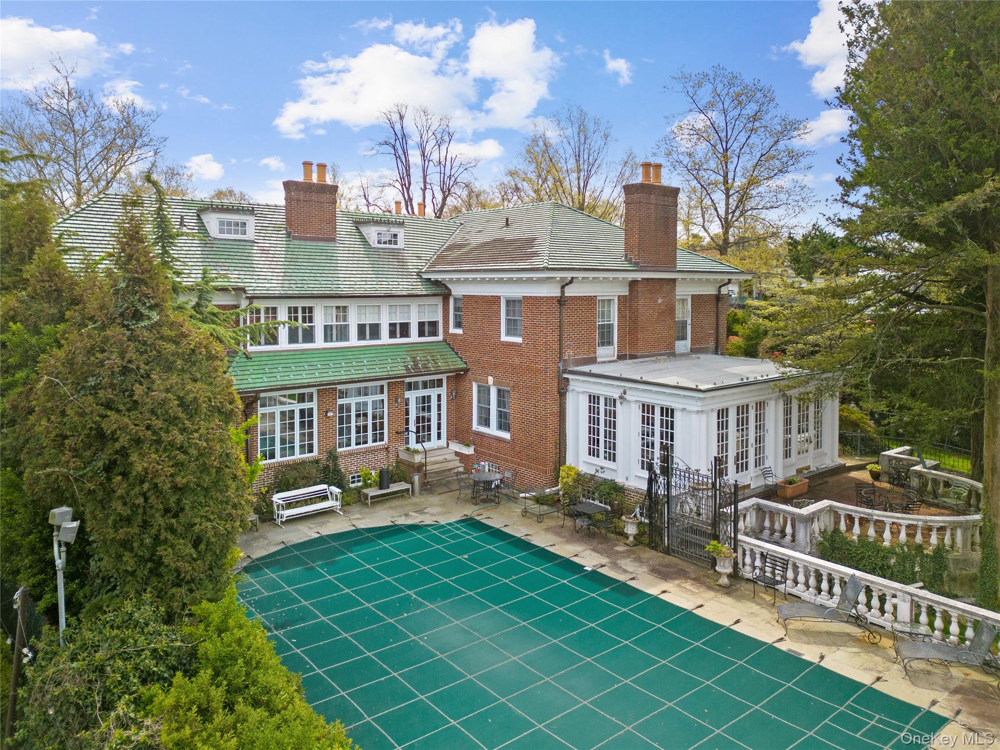 1-27 Beverly Road Queens, NY 11363 - Photo 19 of 46 a front view of a house with swimming pool and trees