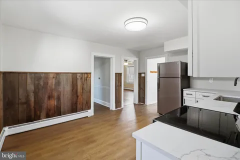 a kitchen with stainless steel appliances granite countertop white cabinets a stove a microwave and a refrigerator