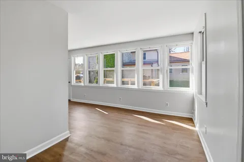 a view of a bedroom with wooden floor and windows