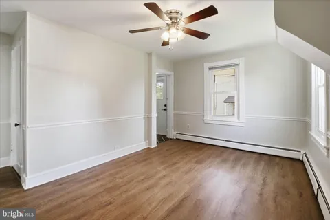 an empty room with windows and fan