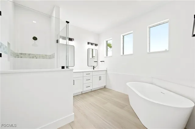a bathroom with a tub sink and mirror