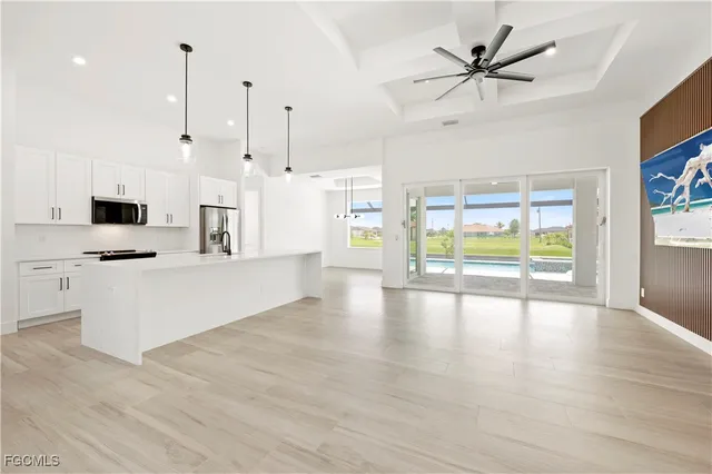 a view of kitchen with stainless steel appliances kitchen island wooden floor and window