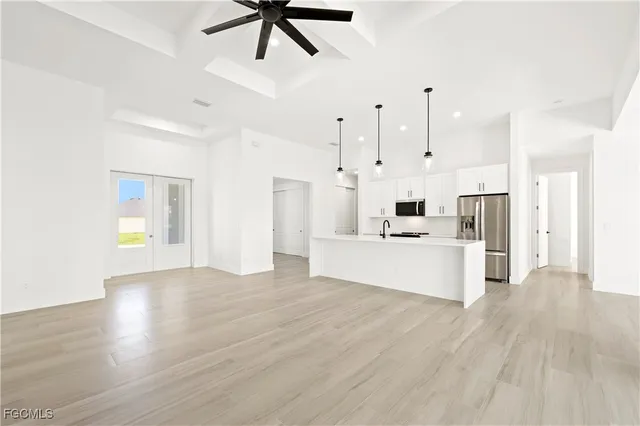 a view of a kitchen with kitchen island a sink stainless steel appliances and cabinets