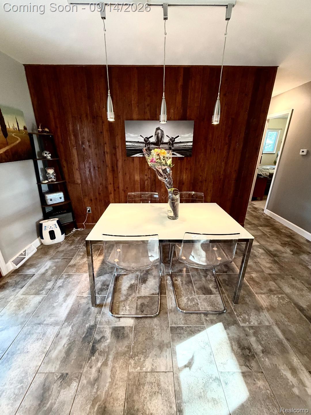 1615 Ladd Road Walled Lake, MI 48390 - Photo 14 of 28 Wood-finish accent wall with a track lighting fixture featuring three pendant lights, complemented by large format tile flooring