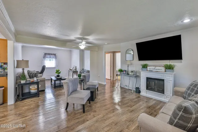 a living room with furniture a chandelier fan and a window