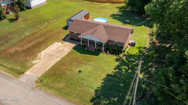 an aerial view of residential houses with outdoor space and trees