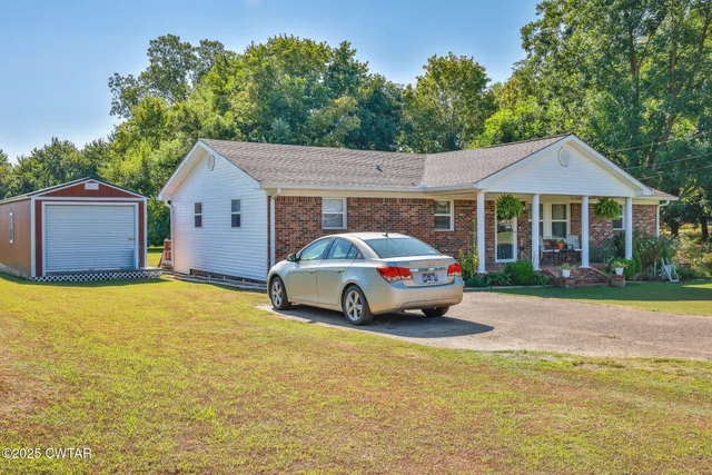 a car parked in front of a house with a yard