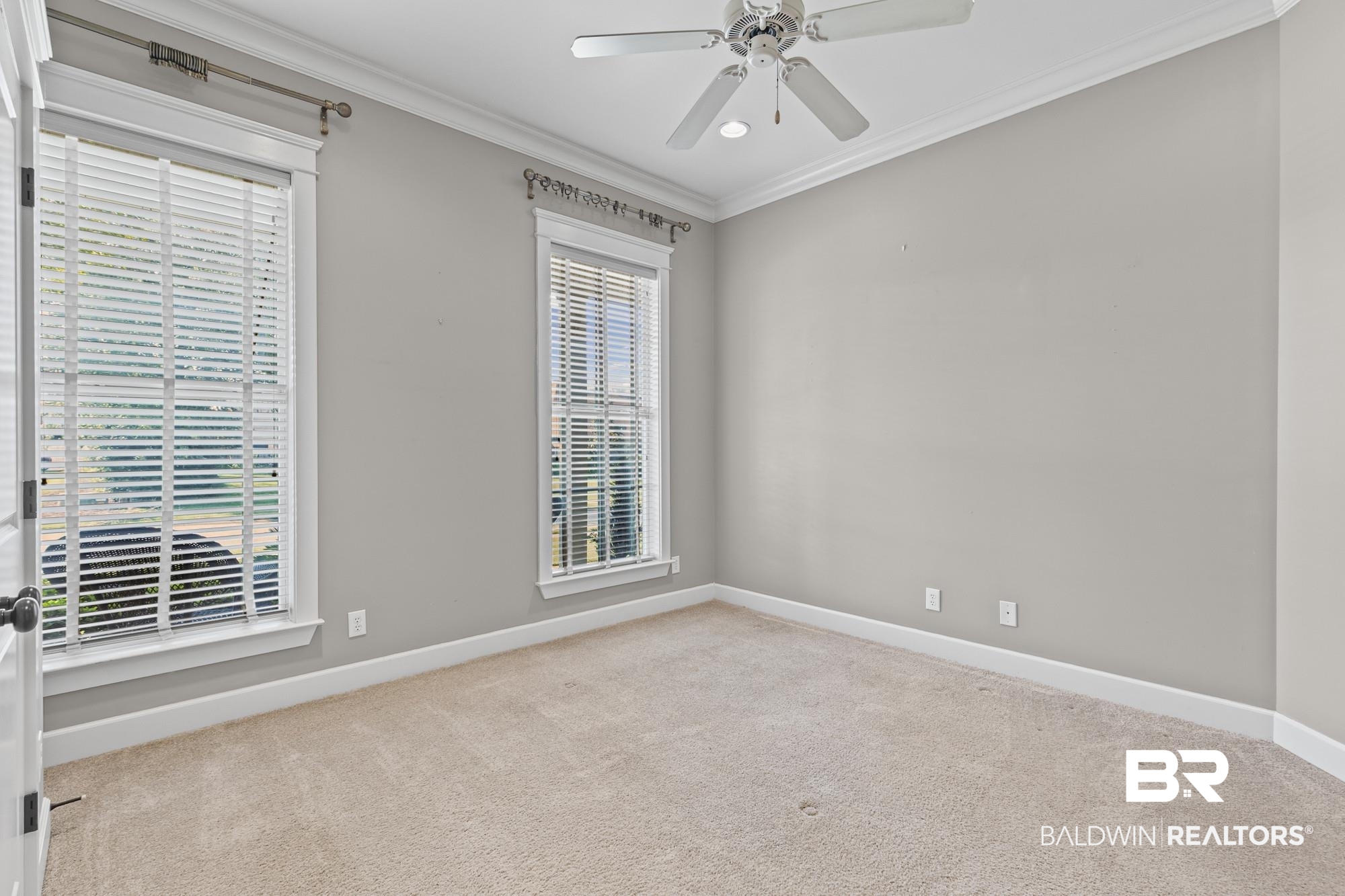 11261 Halcyon Loop Daphne, AL 36526 - Photo 19 of 41 Room featuring two windows with white blinds, neutral carpet flooring, and a ceiling fan with integrated lighting