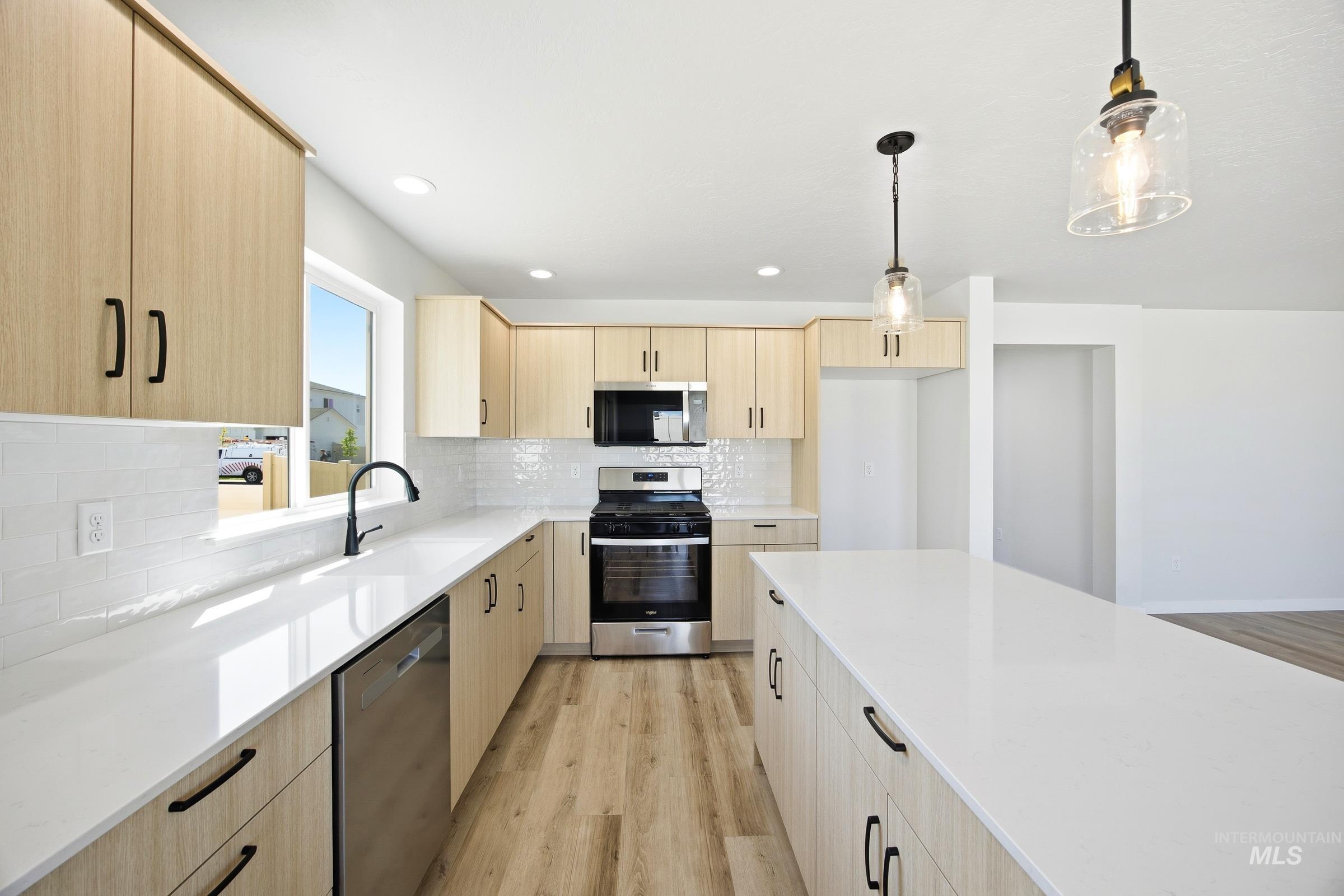 12841 Decatur Street Nampa, ID 83651 - Photo 5 of 30 Modern kitchen featuring light wood-finish cabinetry and white countertops